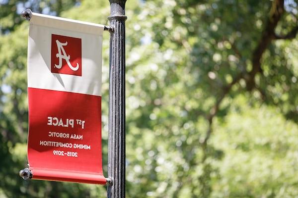 A banner celebrating 皇冠信用盘's 1st place finish in NASA's robotics competition hangs on a light post